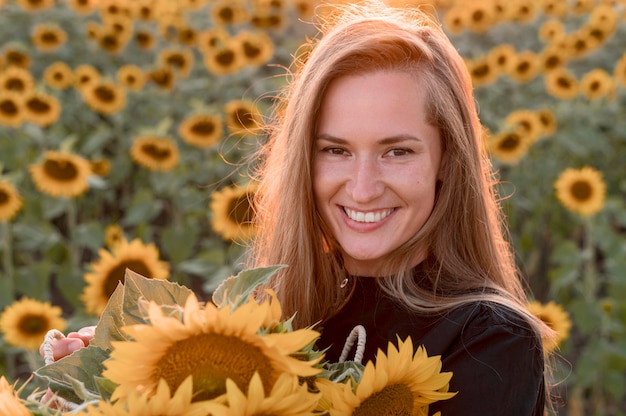Foto smiley vrouw met zonnebloemen