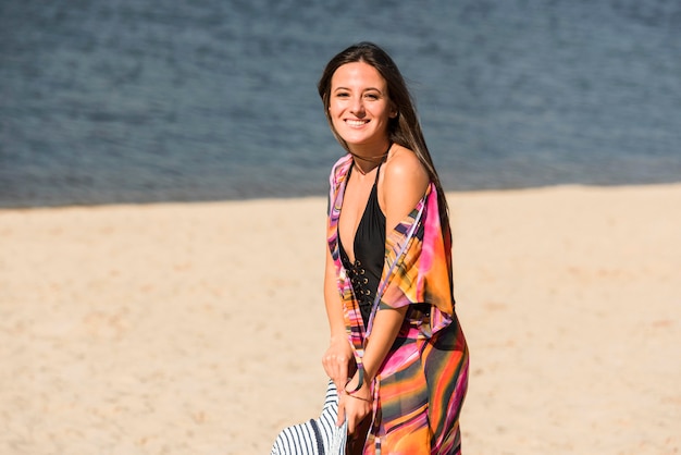 Smiley vrouw poseren terwijl op het strand