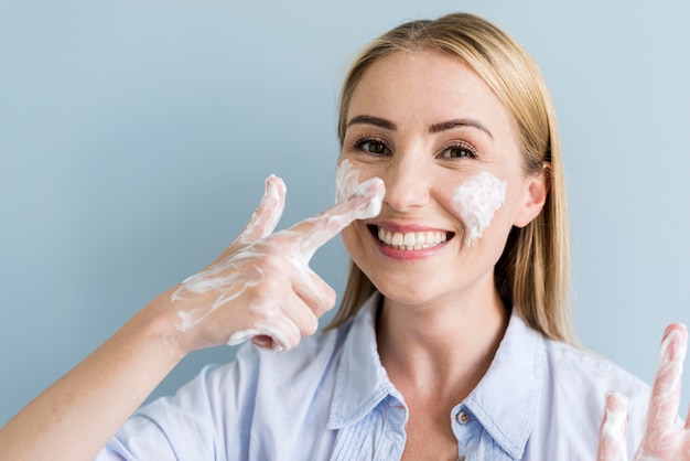 Donna sorridente divertendosi mentre si lava le mani e il viso