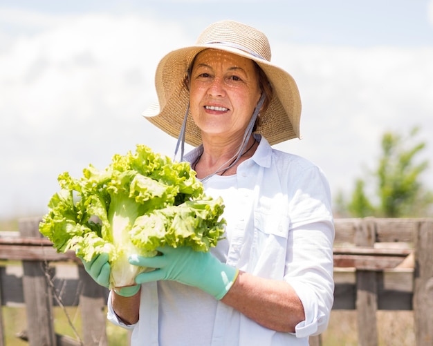 Photo smiley woman holding a fresh cabbage