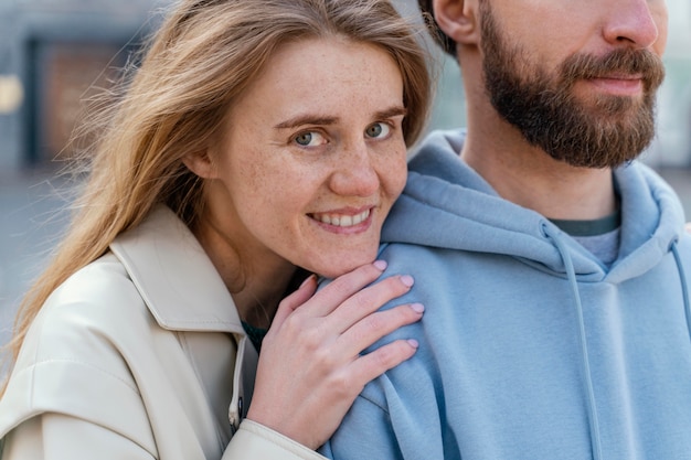 Smiley woman leaning against a man while outdoors