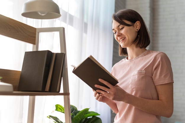 Foto colpo medio del libro di lettura della donna di smiley