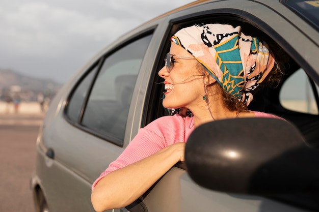 Smiley woman traveling by car close up