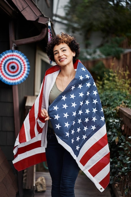 Foto donna sorridente con bandiera all'aperto colpo medio