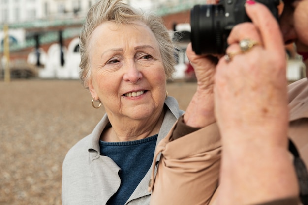 写真 屋外で写真カメラを持つスマイリー女性