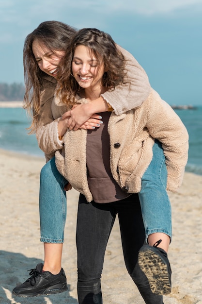 Photo smiley women posing together on beach