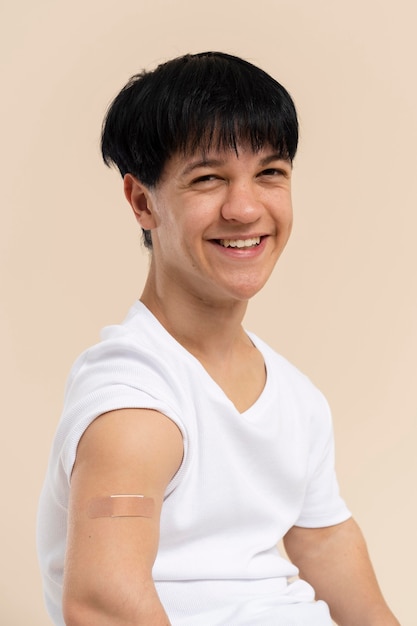 Foto smileyman toont arm met sticker na vaccin