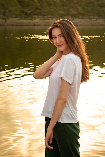 Foto smileyvrouw bij het zijaanzicht van het meer