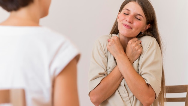 Smileyvrouw die gebarentaal aan iemand onderwijst