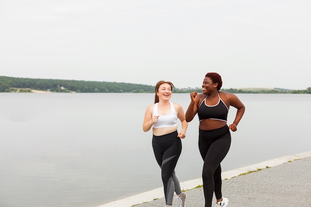 Smileyvrouwen die samen jongleren aan het strand