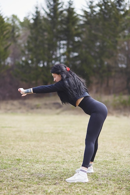 Ragazza attiva sorridente in tuta da allenamento che lavora fuori stile di vita attivo sano