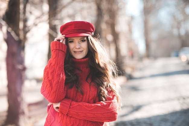 Smiling adult woman old wearing knitted sweater and cap outdoors