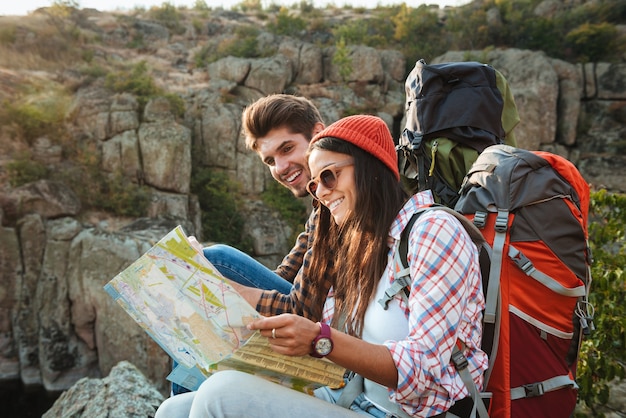 Smiling Adventorous couple with map on slope look at map