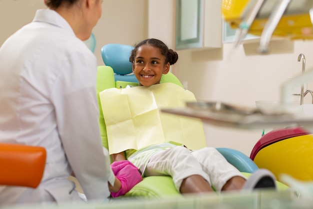 Smiling African American girl looking at a doctor