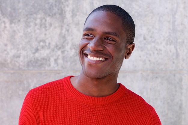 smiling african american guy in red sweater looking away