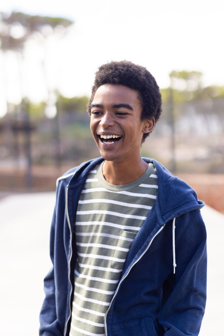Photo smiling african american teenage boy in casual clothes enjoying outdoor hangout with friends