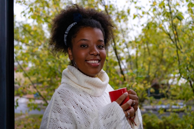 Smiling African American woman drinking coffee