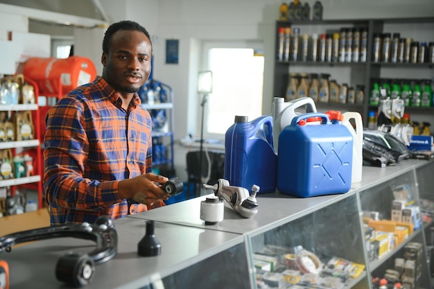 Photo smiling african salesman auto parts store