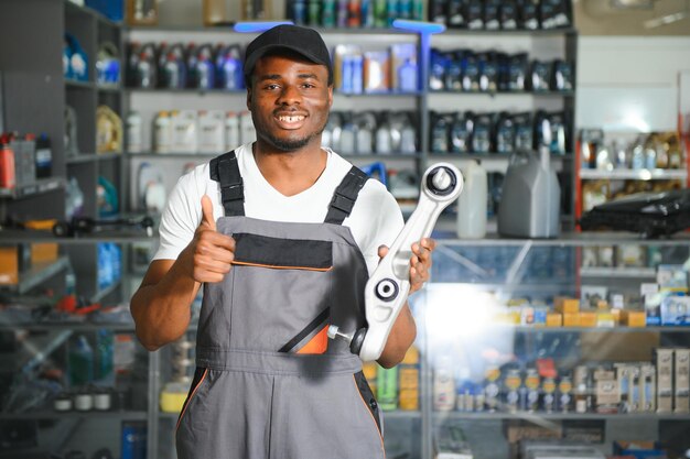 Photo smiling african salesman auto parts store