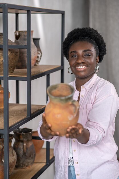 Smiling african woman in pink clothes in the ceramic studio