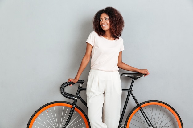 Smiling african woman posing with bicycle