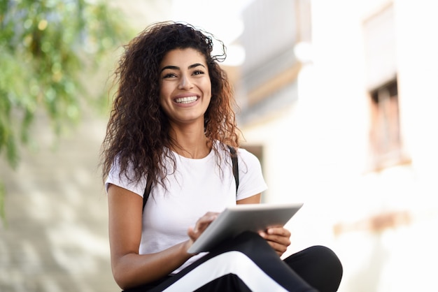 Smiling african woman using digital tablet outdoors