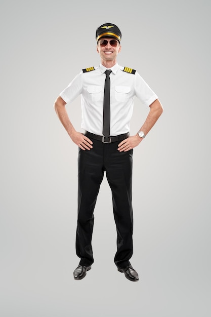 Smiling airline captain with hands on hips