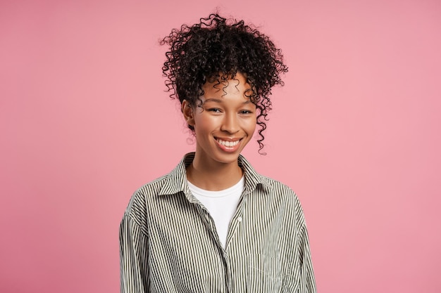 smiling arfican american woman wearing shirt looking at camera standing isolated