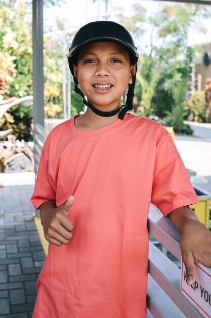 Smiling Asian boy in helmet ready to learning horseback riding