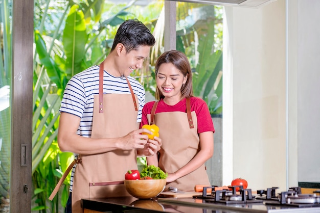 Smiling asian couple cooking for lunch