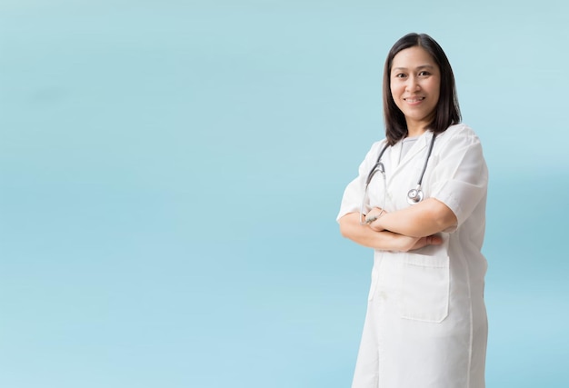 Smiling asian female doctor coat with posing arms crossed isolated on blue background with Clipping paths for design work empty free space