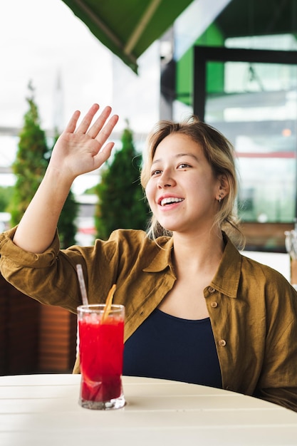 Smiling asian girl waving to someone