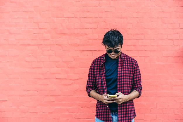 Smiling asian hipster using mobile phone outdoor oriental
social influencer having fun with new trends smartphone apps
generation z tech and youth millennial people lifestyle