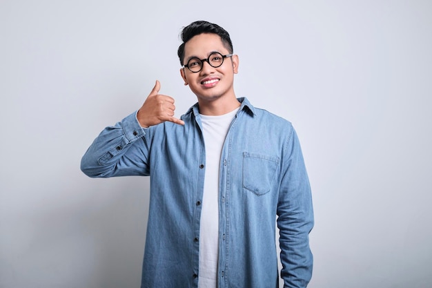 Foto un uomo asiatico sorridente che fa un gesto telefonico come dice di richiamarmi concetto di stile di vita delle persone