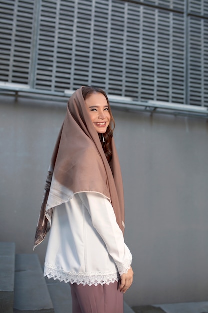 Foto ragazza musulmana asiatica sorridente nel hijab marrone