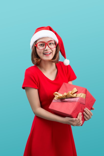 Smiling asian woman in red santa hat holding present box