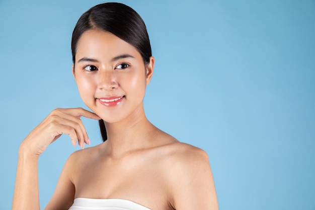 Donna asiatica sorridente che tocca il ritratto sano della pelle. modello di bella ragazza felice con luce fresca.