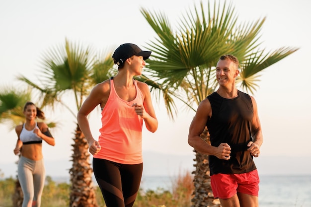 Foto atleti sorridenti che fanno jogging all'aperto e parlano tra loro.