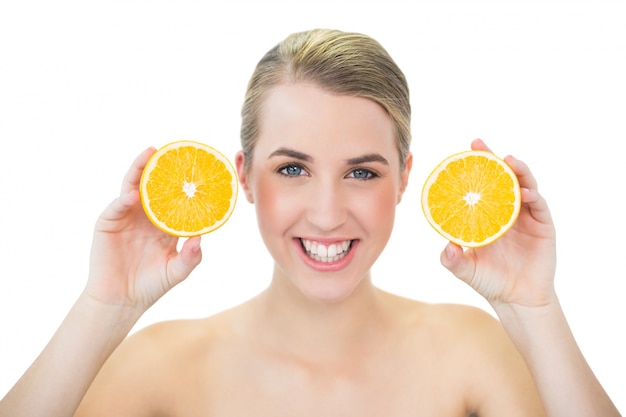 Smiling attractive blonde holding orange slices