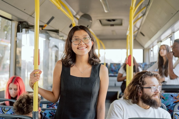 Foto studente attraente sorridente in una strana città che si muove con i mezzi pubblici