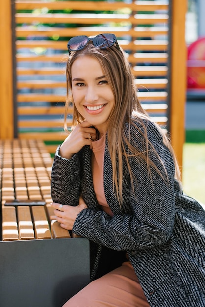 Smiling attractive young woman sitting at the bar in a street cafe