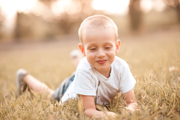 Smiling baby boy having fun lying on grass