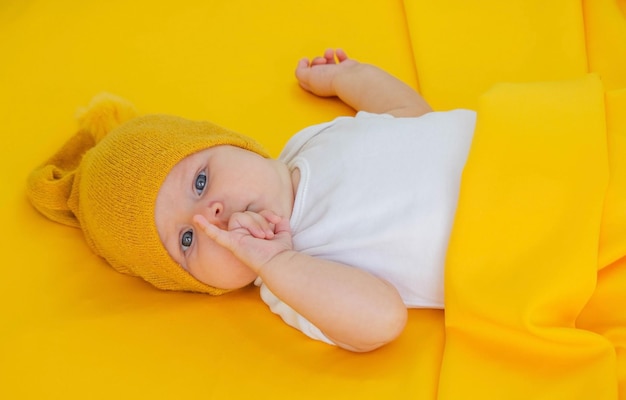 smiling baby girl goes to sleep with a teddy bear on a yellow background children