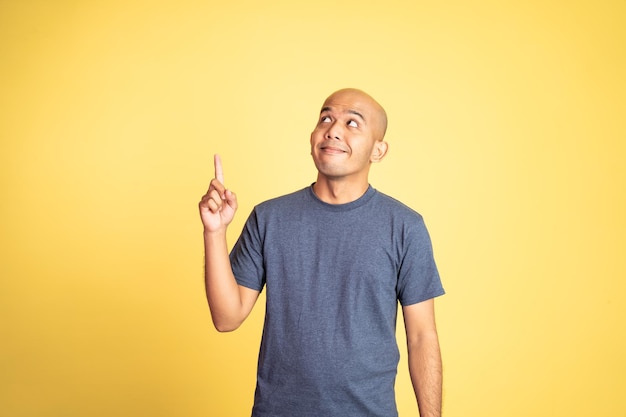 Photo smiling bald man with finger pointing up