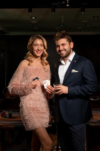 Foto ragazzo barbuto sorridente e donna bionda che celebrano il poker vincente nel casinò