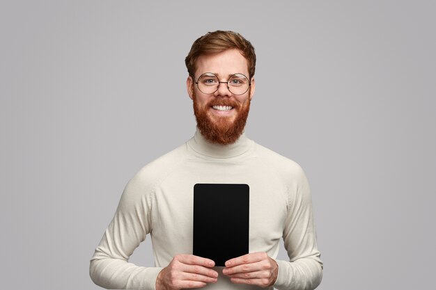 Smiling bearded guy showing tablet with empty screen