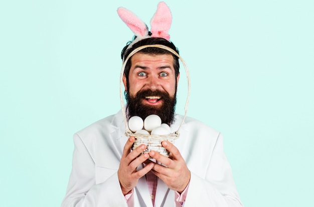 Uomo barbuto sorridente in vestito con le uova del cesto. preparazione per la pasqua. caccia alle uova. vacanze pasquali.