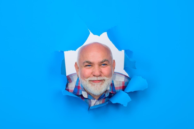 Smiling bearded man through hole in blue paper discount sale season sales sellout through paper