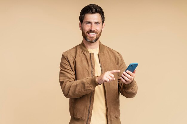 Photo smiling bearded man using smartphone browsing internet scrolling news feed checking social media