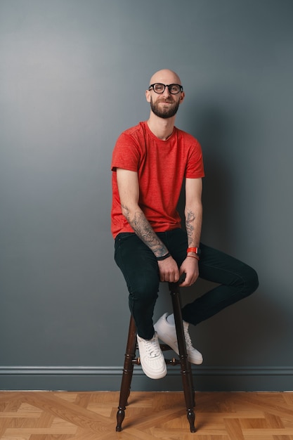 Smiling bearded young man on gray